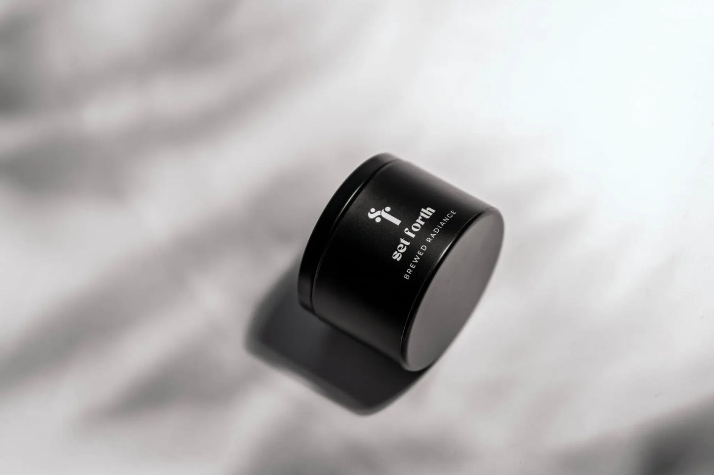 Brewed Radiance candle in matte black tin.