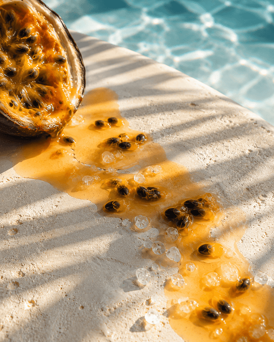Halved passionfruit with pulp and sea salt beside blue water