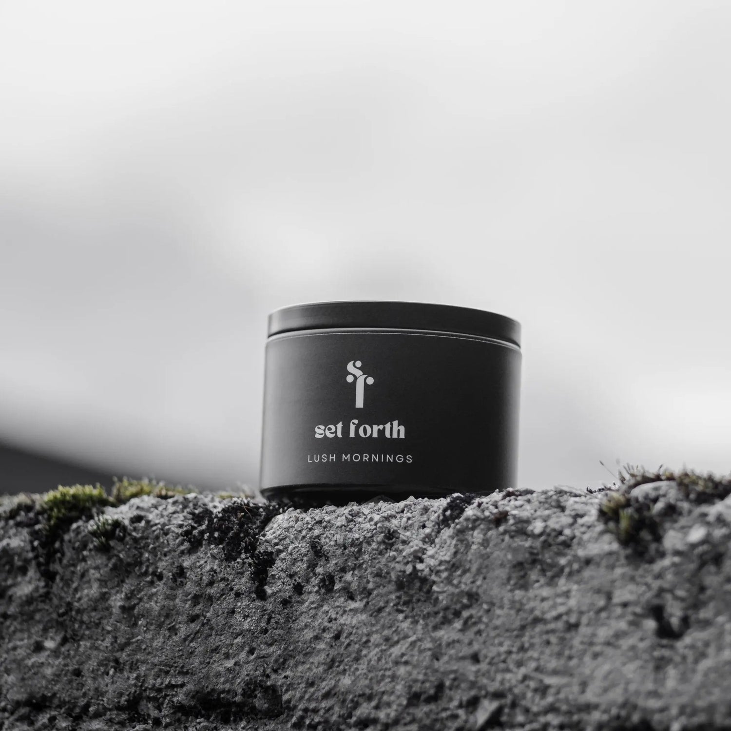Lush Mornings candle in matte black tin.