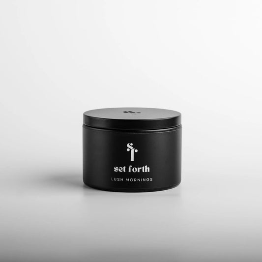 Lush Mornings candle in matte black tin.