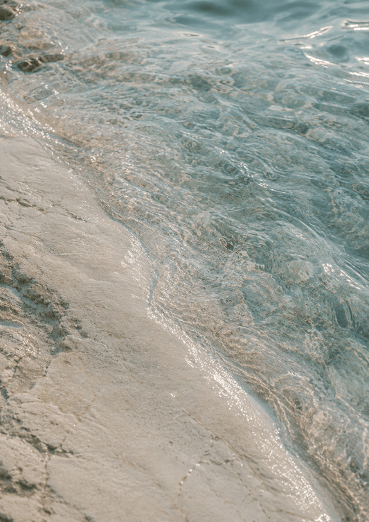 Clear ocean water washing over pale sand